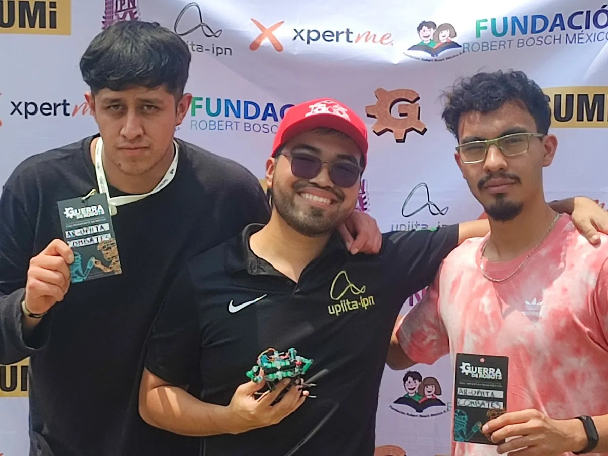 AR-UPIITA teammates holding combat robots at the Guerra de Robots event